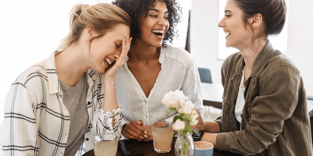3 frauen sitzen in einem caffee und lachen