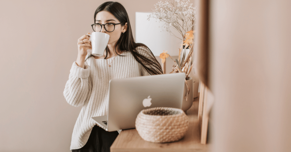 frau trinkt kaffee und arbeitet am laptop